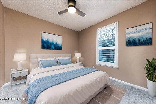 carpeted bedroom with a textured ceiling and ceiling fan