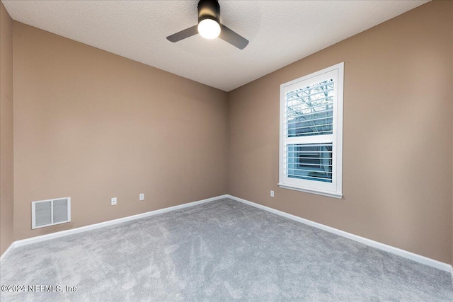 spare room with light carpet, a textured ceiling, and ceiling fan