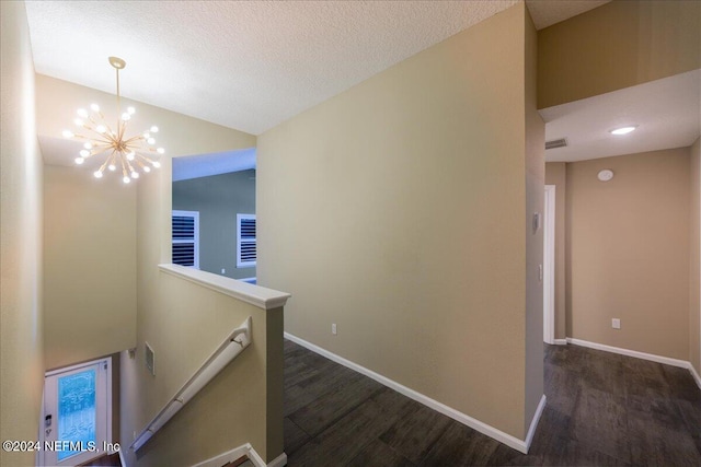 hallway with an inviting chandelier, vaulted ceiling, and dark hardwood / wood-style floors