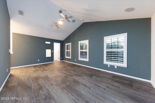 empty room featuring dark wood-type flooring, ceiling fan, a textured ceiling, and vaulted ceiling