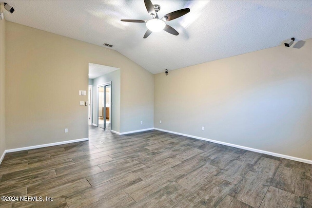 spare room featuring a textured ceiling, ceiling fan, vaulted ceiling, and dark hardwood / wood-style flooring