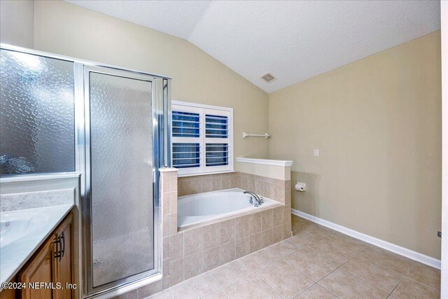 bathroom featuring plus walk in shower, a textured ceiling, lofted ceiling, vanity, and tile patterned flooring