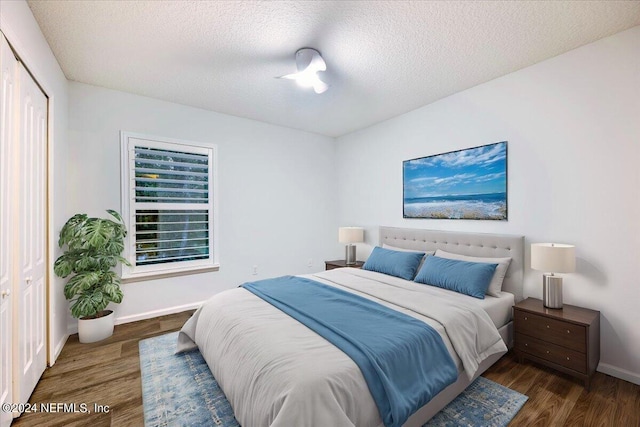 bedroom featuring a closet, a textured ceiling, and dark hardwood / wood-style floors