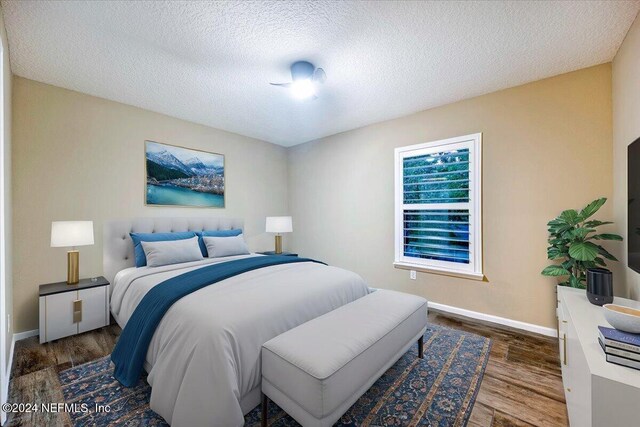 bedroom featuring a textured ceiling and dark hardwood / wood-style floors