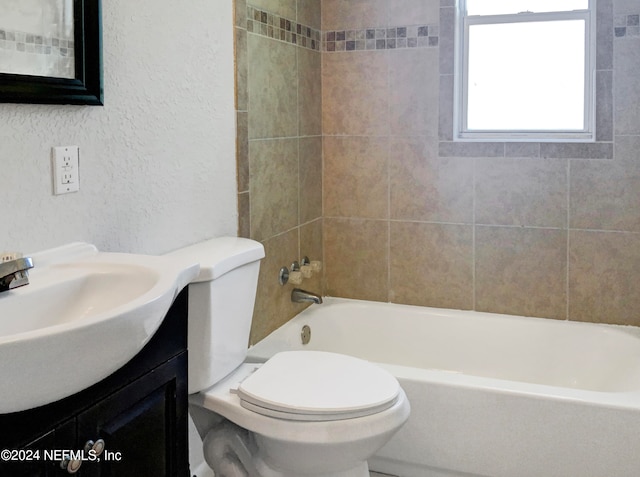 full bathroom featuring tiled shower / bath combo, large vanity, and toilet