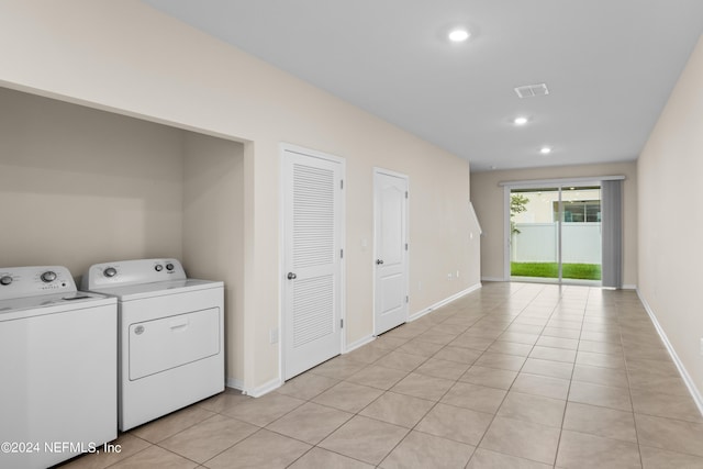 clothes washing area featuring light tile patterned floors and washer and clothes dryer