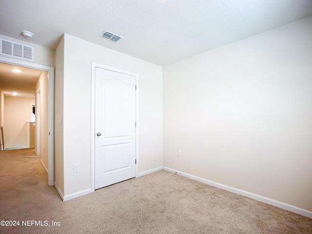 unfurnished bedroom featuring light carpet