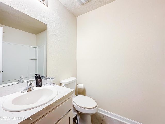 bathroom with vanity, tile patterned flooring, a textured ceiling, and toilet