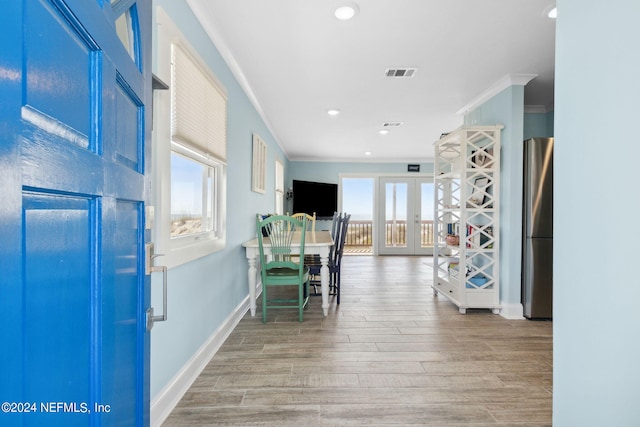 hall featuring light hardwood / wood-style flooring, french doors, and ornamental molding