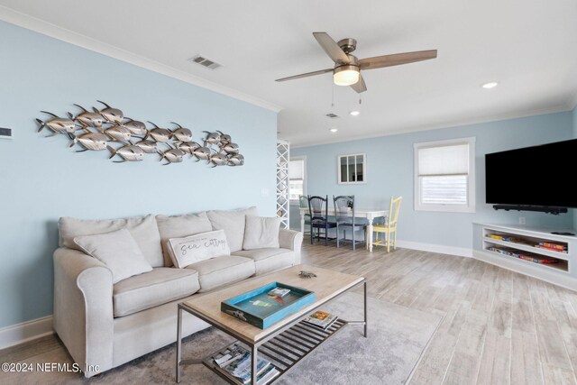 living room featuring ceiling fan, crown molding, and light wood-type flooring