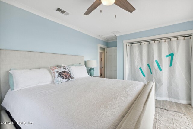 bedroom featuring ornamental molding, ceiling fan, and light hardwood / wood-style flooring