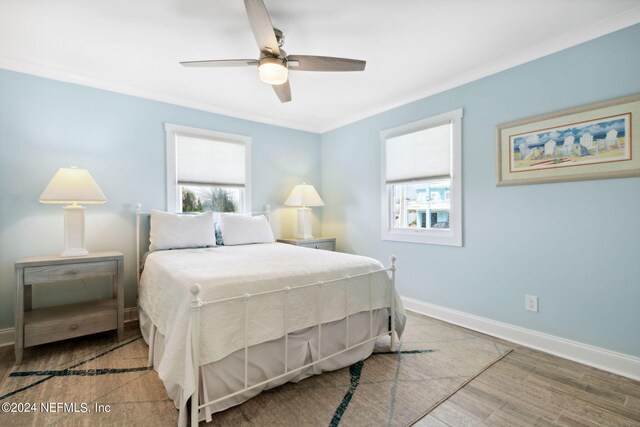 bedroom with light hardwood / wood-style flooring, ceiling fan, and crown molding