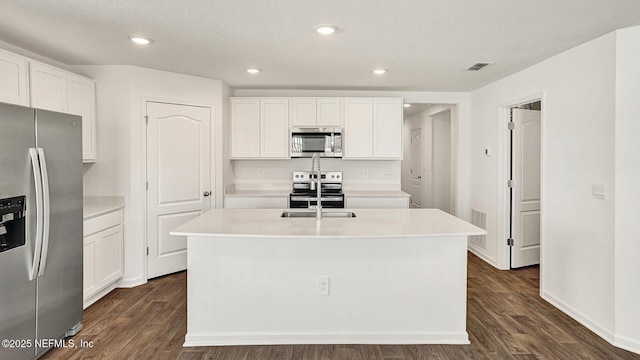 kitchen featuring appliances with stainless steel finishes, a center island with sink, and white cabinets