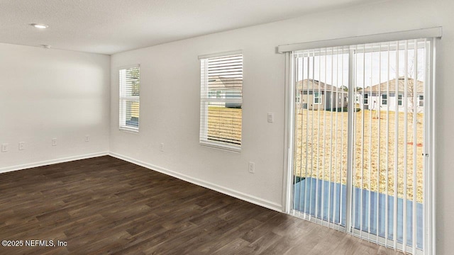 spare room featuring hardwood / wood-style floors and a textured ceiling