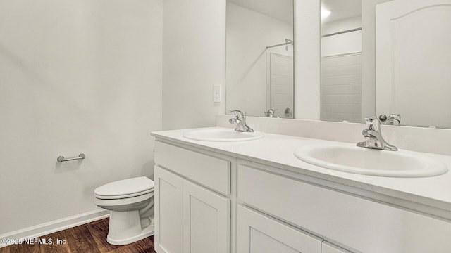 bathroom with vanity, hardwood / wood-style flooring, toilet, and walk in shower