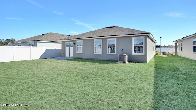 back of house with cooling unit and a lawn