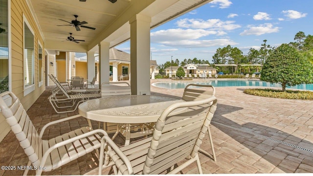 view of patio with a community pool and ceiling fan