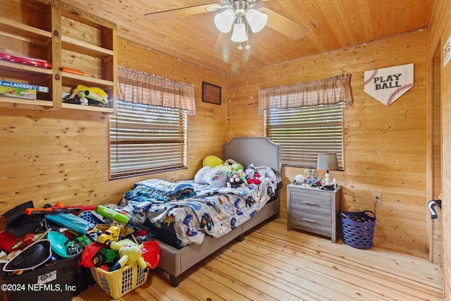 bedroom featuring wood ceiling, light hardwood / wood-style flooring, wooden walls, and ceiling fan