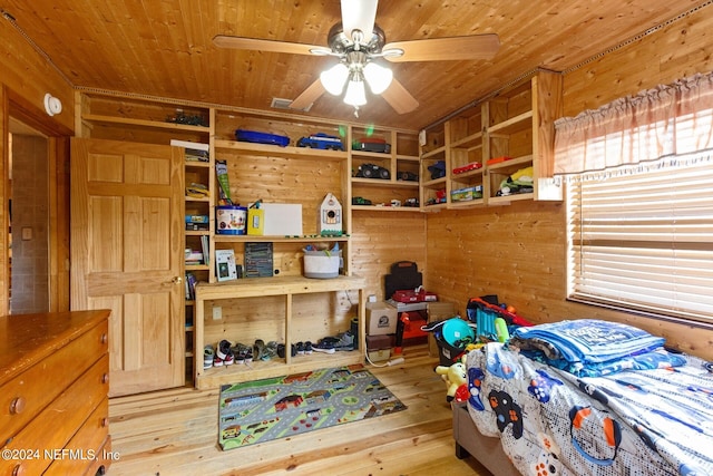 bedroom featuring wooden ceiling, ceiling fan, light wood-type flooring, and wooden walls