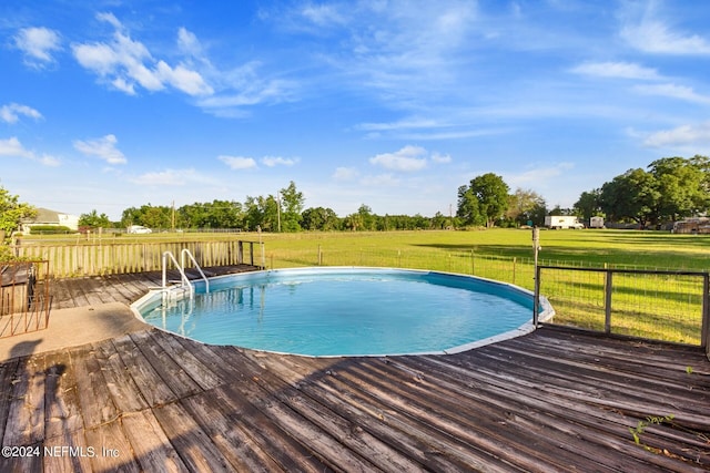 view of swimming pool with a deck and a yard