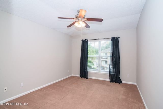 empty room with light carpet, a textured ceiling, and ceiling fan