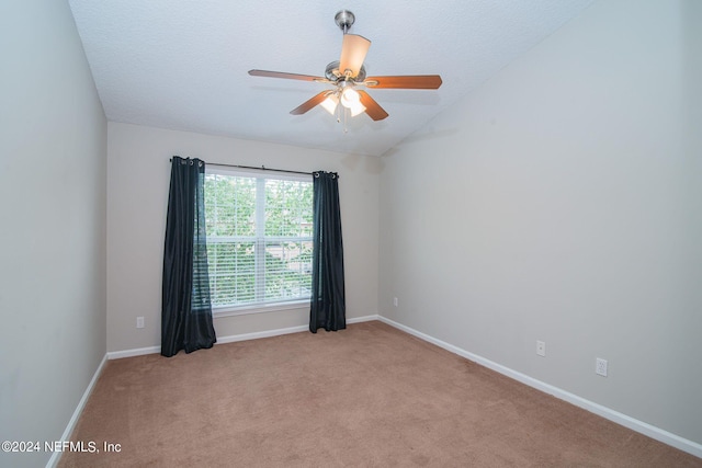 carpeted spare room featuring lofted ceiling, ceiling fan, and a textured ceiling