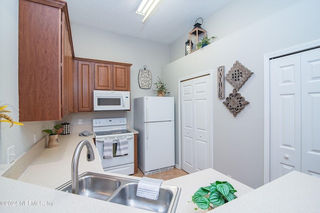 kitchen featuring a textured ceiling, sink, and white appliances