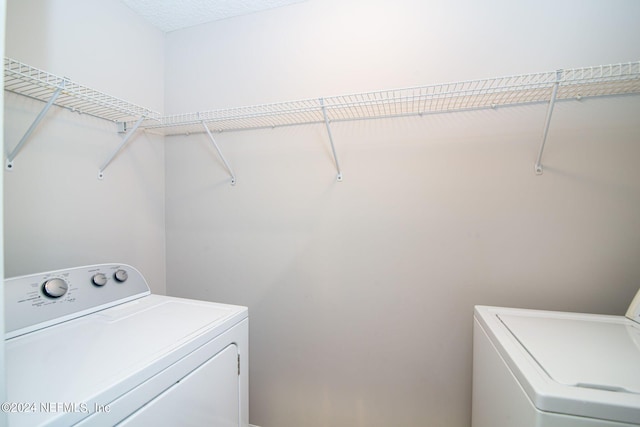 clothes washing area with washing machine and dryer