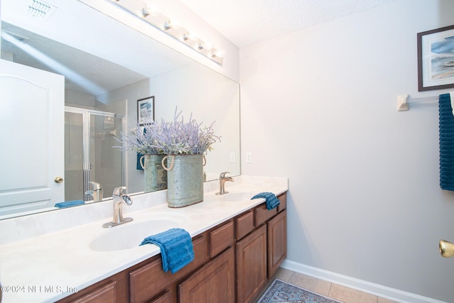 bathroom featuring tile patterned flooring, walk in shower, a textured ceiling, and vanity