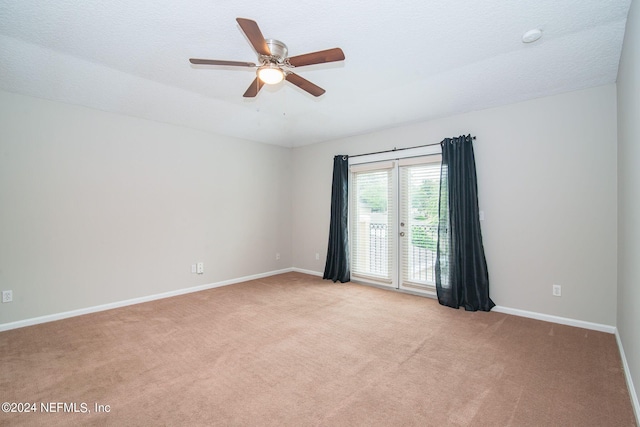 carpeted empty room featuring ceiling fan and a textured ceiling