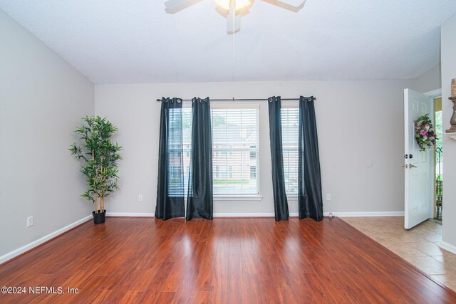 unfurnished room featuring a textured ceiling, wood-type flooring, and ceiling fan