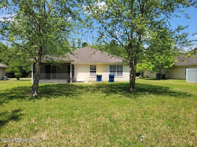 1450 Elsa Dr, Jacksonville, FL 32218 - rear view of property with a sunroom, stucco siding, and a yard
