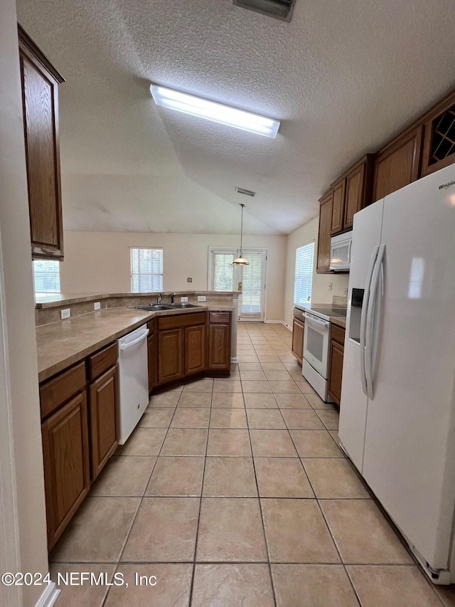 1450 Elsa Dr, Jacksonville, FL 32218 - kitchen with a sink, a peninsula, brown cabinetry, light tile patterned floors, and white appliances