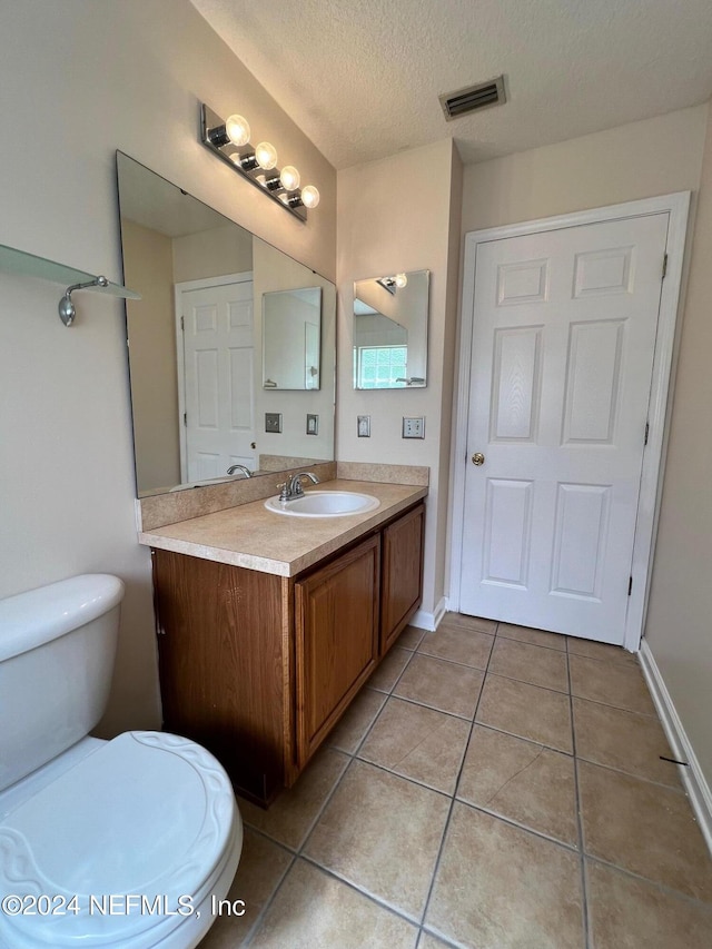 1450 Elsa Dr, Jacksonville, FL 32218 - bathroom with a textured ceiling, visible vents, toilet, tile patterned floors, and vanity