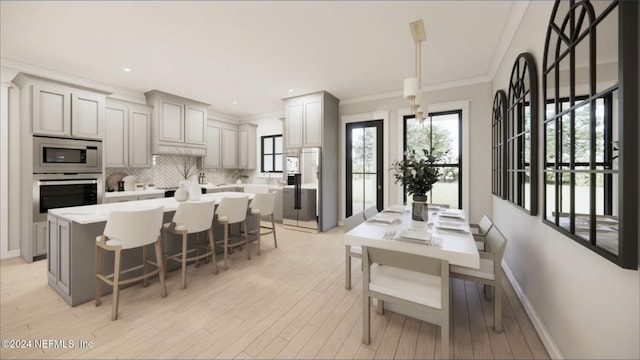 dining space featuring ornamental molding and light hardwood / wood-style flooring