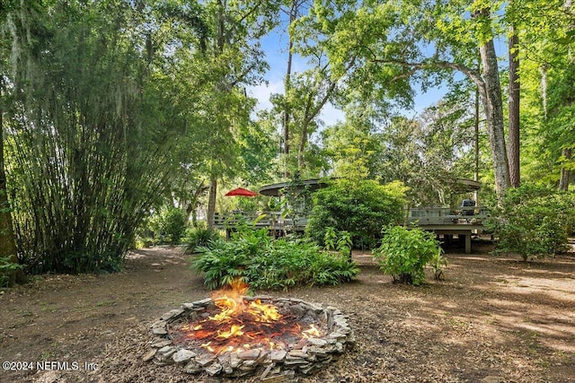 view of yard with a wooden deck and a fire pit