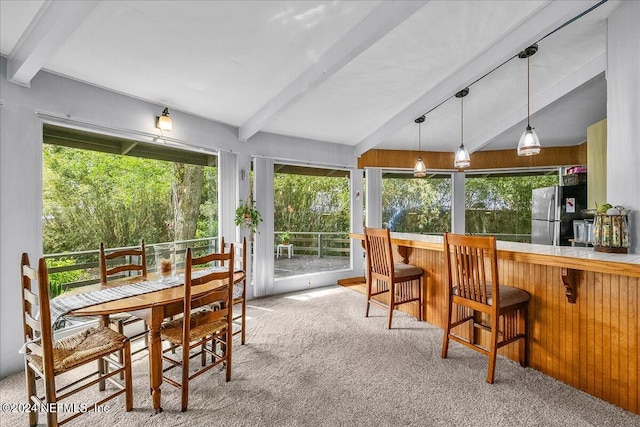 sunroom / solarium featuring track lighting and vaulted ceiling with beams