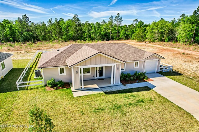 ranch-style home featuring covered porch, a garage, and a front lawn