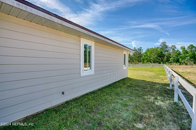 view of side of home with a yard