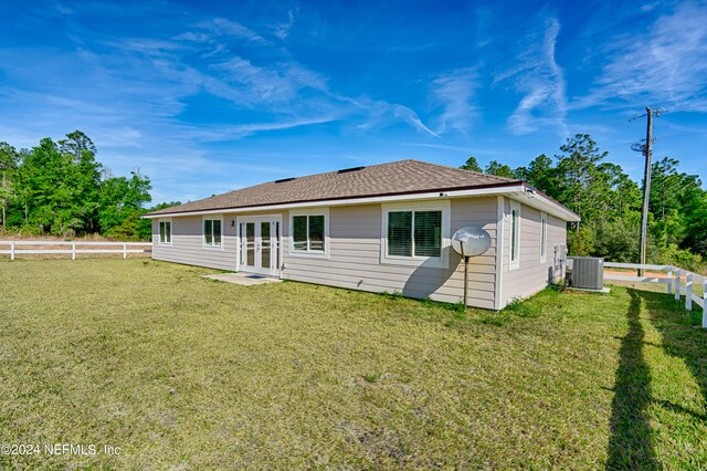 back of house with french doors, central AC, and a lawn