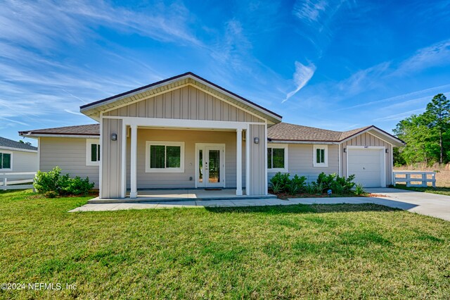 ranch-style home featuring french doors, a garage, and a front lawn