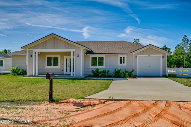 ranch-style home with a garage and a front lawn