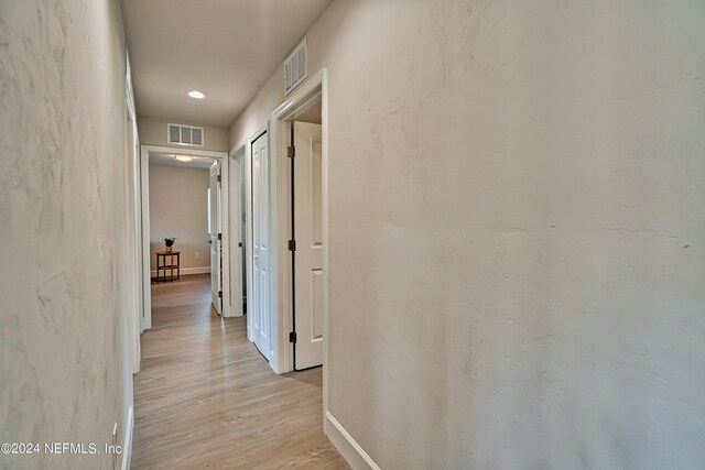 hallway with light hardwood / wood-style floors