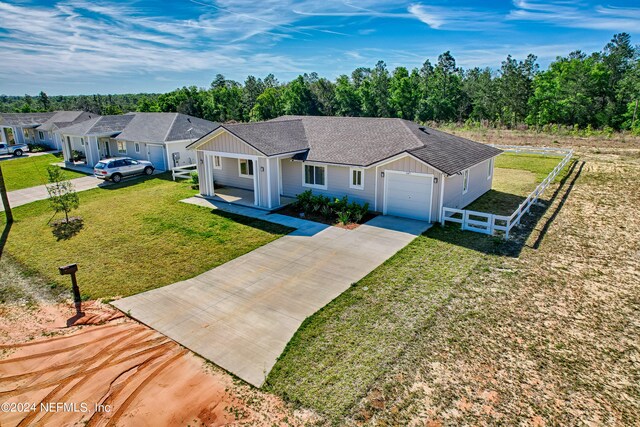 ranch-style house featuring a garage and a front lawn