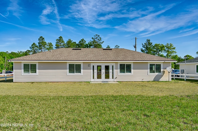 rear view of property with french doors and a yard