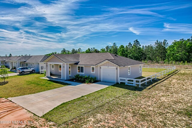 single story home featuring a front lawn and a garage