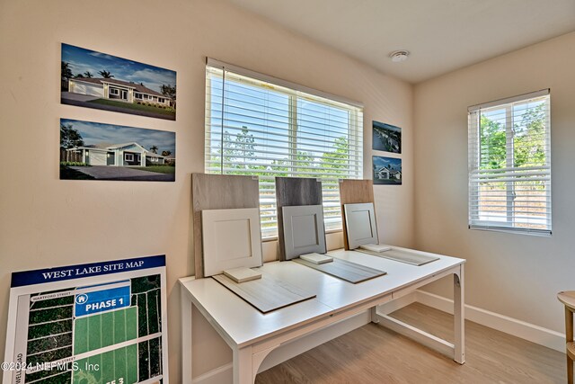 office with a healthy amount of sunlight and light hardwood / wood-style floors