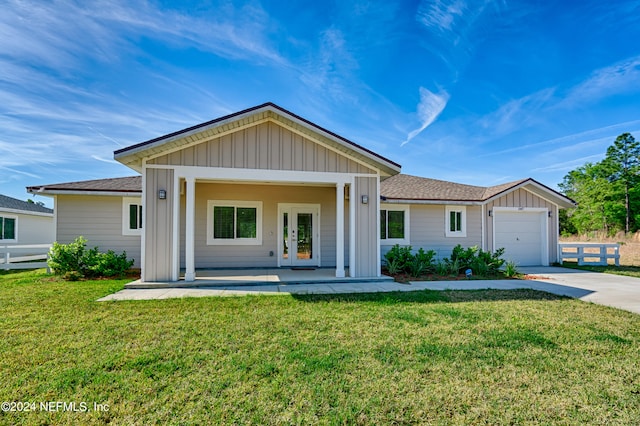 ranch-style home with french doors, a garage, and a front yard