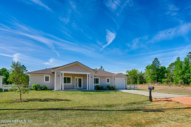 ranch-style home featuring a garage and a front lawn