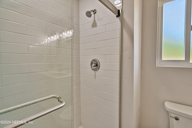 bathroom with toilet and a tile shower